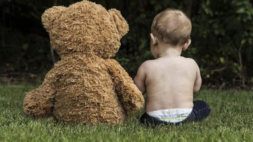 baby and bear in play garden